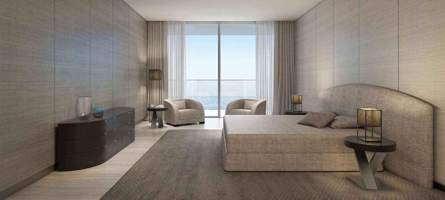 Bedroom with upholstered bed, armchairs and full-height window onto the sea