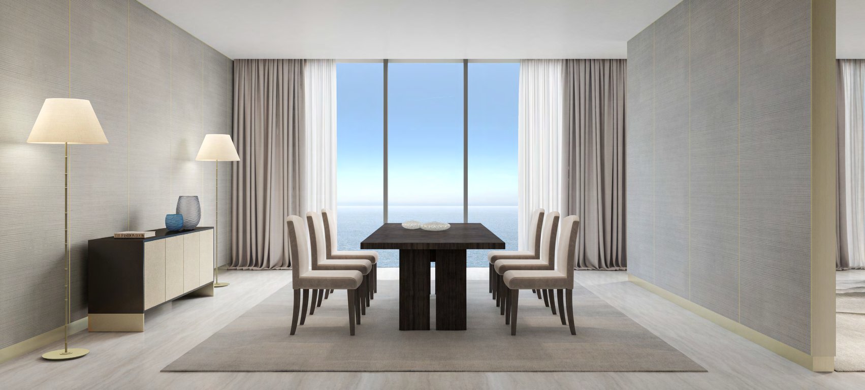 Dining table for eight in front of floor-to-ceiling windows onto the sea