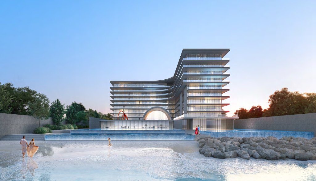 Beach, shallow water and infinity pools in front of the building at dusk