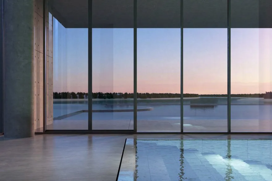 Indoor pool with concrete columns and floor-to-ceiling glass facing the water